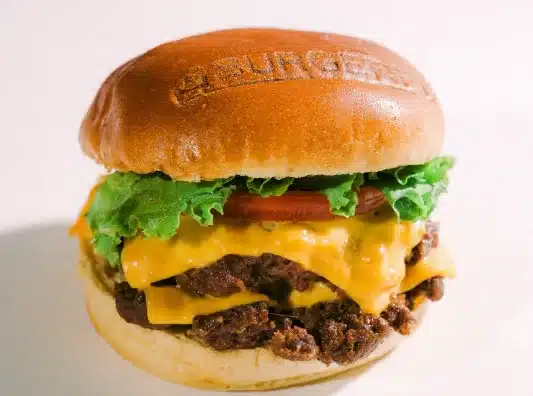 A juicy burger from BurgerFi against a white background. 